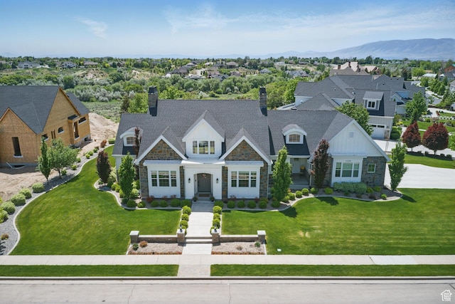 view of front facade with stone siding, a chimney, a residential view, and a front yard