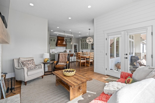 living room with french doors, light wood finished floors, and recessed lighting
