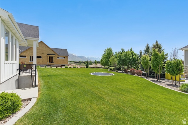 view of green lawn featuring a mountain view