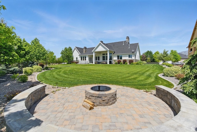 back of house featuring a patio, an outdoor fire pit, and a yard