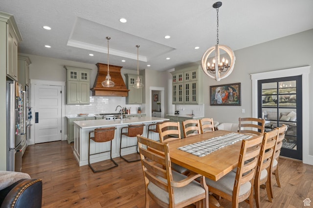 dining room featuring a chandelier, a raised ceiling, dark wood-style floors, and recessed lighting