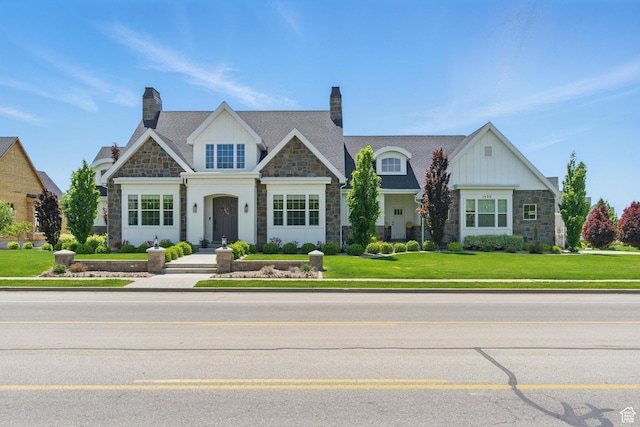craftsman-style house featuring stone siding, board and batten siding, and a front lawn