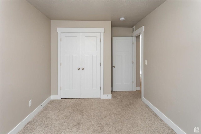 1704 E Talon Way, Eagle Mountain, UT 84005 - unfurnished bedroom featuring baseboards, visible vents, light carpet, and a closet