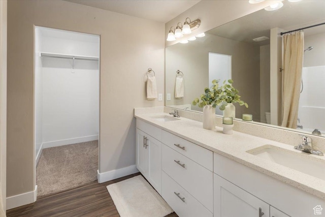 1704 E Talon Way, Eagle Mountain, UT 84005 - full bathroom featuring double vanity, baseboards, a sink, and wood finished floors