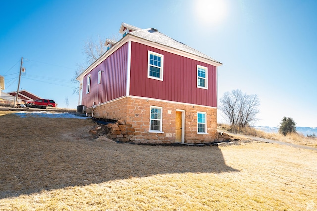 view of property exterior featuring a shingled roof and central AC
