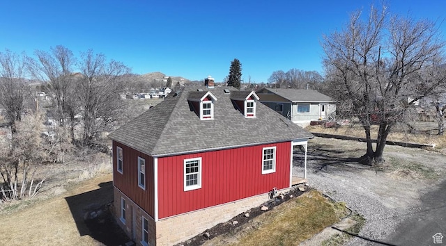 view of side of home with a garage and a shingled roof