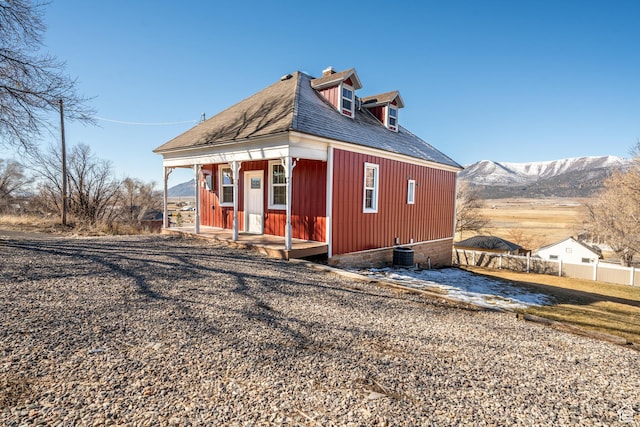 view of property exterior with a chimney, fence, and a mountain view