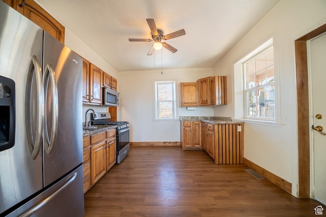 kitchen with stainless steel appliances, dark wood-style flooring, visible vents, and baseboards