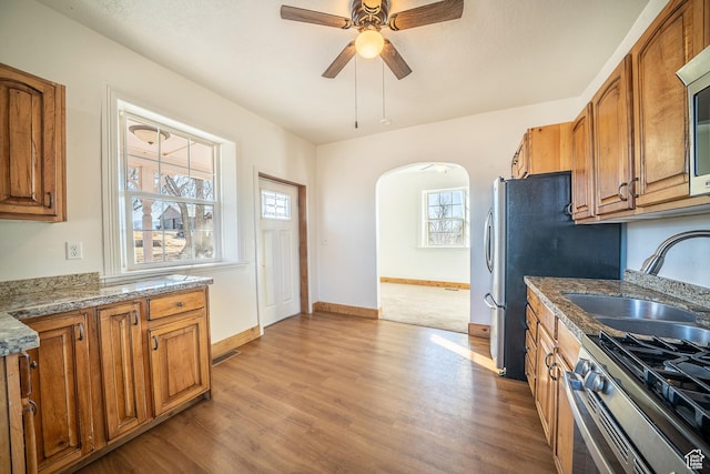 kitchen with a wealth of natural light, brown cabinets, and a sink