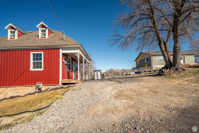 view of side of property with roof with shingles
