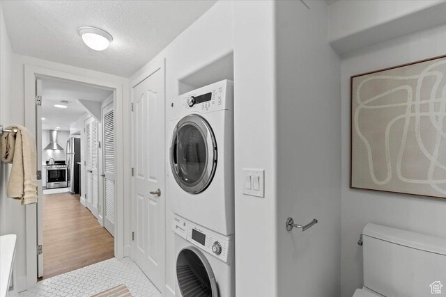 251 N Center St W, Salt Lake City, UT 84103 - clothes washing area with stacked washer and clothes dryer, light tile patterned flooring, and a textured ceiling