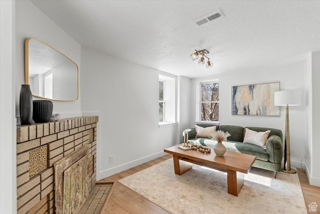 251 N Center St W, Salt Lake City, UT 84103 - living room featuring light wood-type flooring, visible vents, a textured ceiling, and baseboards