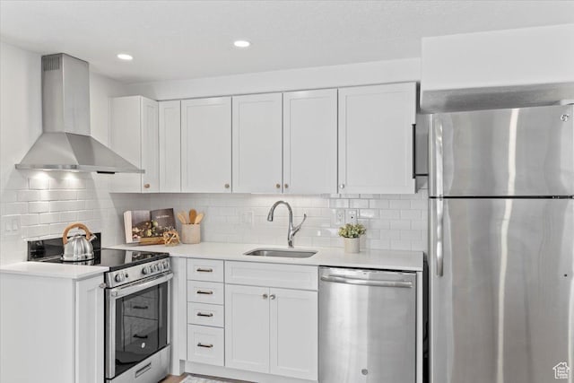 251 N Center St W, Salt Lake City, UT 84103 - kitchen featuring white cabinets, stainless steel appliances, light countertops, wall chimney range hood, and a sink