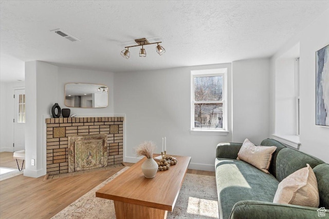251 N Center St W, Salt Lake City, UT 84103 - living room with a textured ceiling, a brick fireplace, wood finished floors, and visible vents