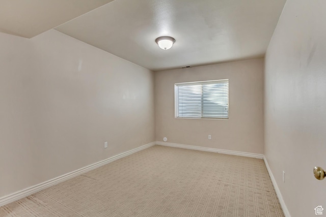 empty room with light colored carpet, visible vents, and baseboards