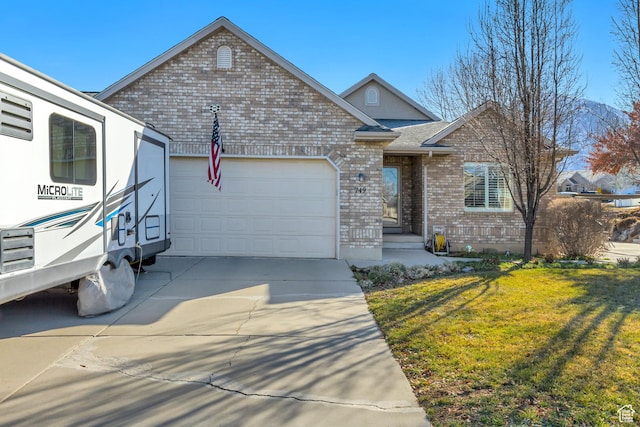 view of front of home with a garage, a front yard, concrete driveway, and brick siding