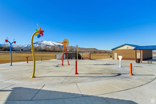 surrounding community featuring a mountain view and playground community