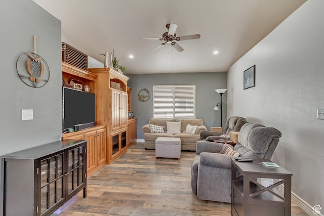 living area with light wood-style flooring, baseboards, a ceiling fan, and recessed lighting