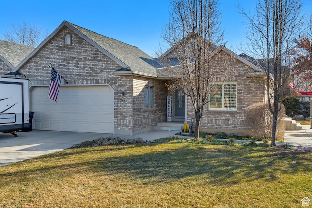 ranch-style house featuring brick siding, roof with shingles, concrete driveway, a front yard, and a garage