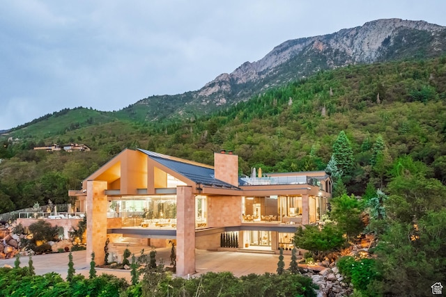 3826 E Thousand Oaks Cir, Salt Lake City, UT 84124 - back of property with a chimney, a wooded view, a mountain view, and stucco siding