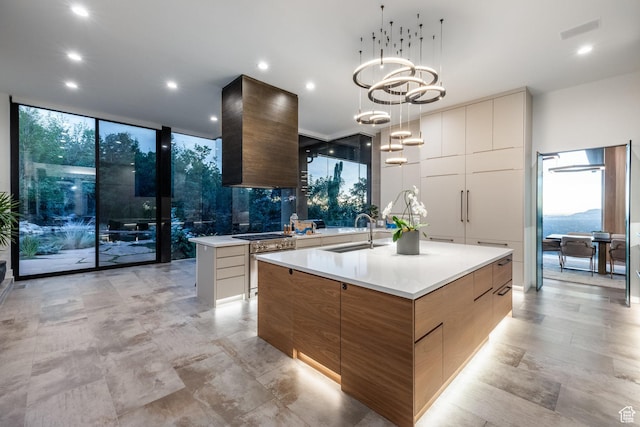 3826 E Thousand Oaks Cir, Salt Lake City, UT 84124 - kitchen with modern cabinets, a large island with sink, wall chimney range hood, floor to ceiling windows, and a sink