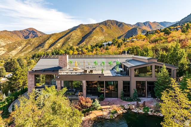3826 E Thousand Oaks Cir, Salt Lake City, UT 84124 - back of house featuring a chimney, a patio area, a mountain view, and stucco siding