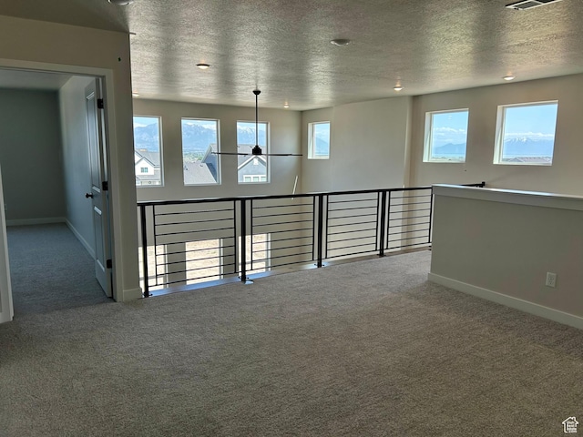 1552 N Cozy Ln Unit 05, Saratoga Springs, UT 84045 - unfurnished room with carpet floors, a textured ceiling, plenty of natural light, and baseboards