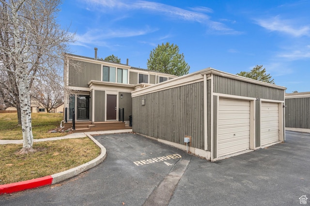 view of front of home with a garage, an outbuilding, and a front yard