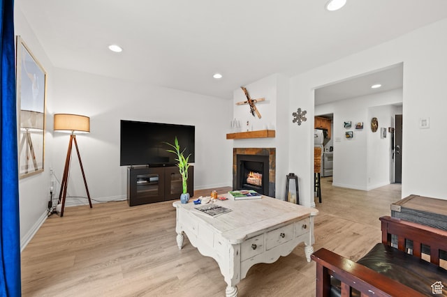 living area featuring light wood finished floors, recessed lighting, baseboards, and a tile fireplace