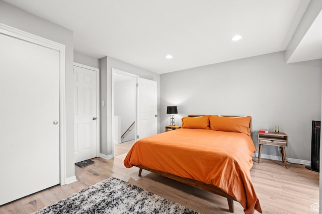 bedroom with light wood-type flooring, baseboards, and recessed lighting