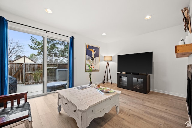 living room with baseboards, light wood finished floors, a fireplace, and recessed lighting