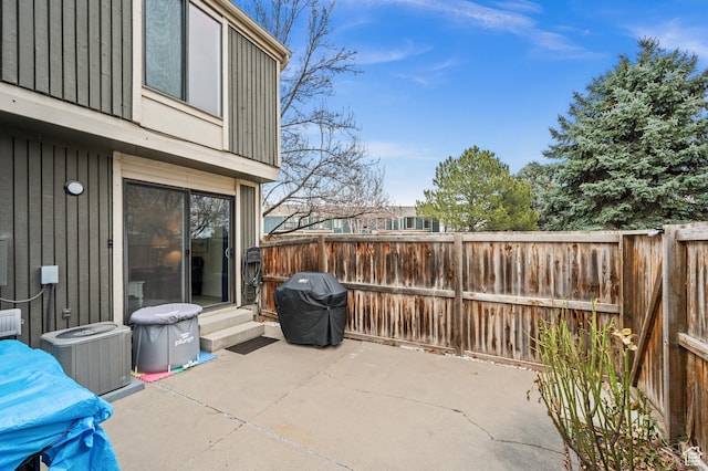 view of patio with central AC unit, area for grilling, and fence