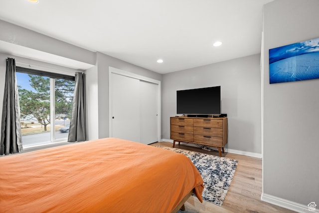 bedroom with recessed lighting, a closet, baseboards, and wood finished floors