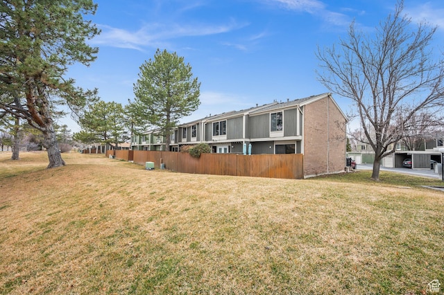 back of house featuring a lawn and fence
