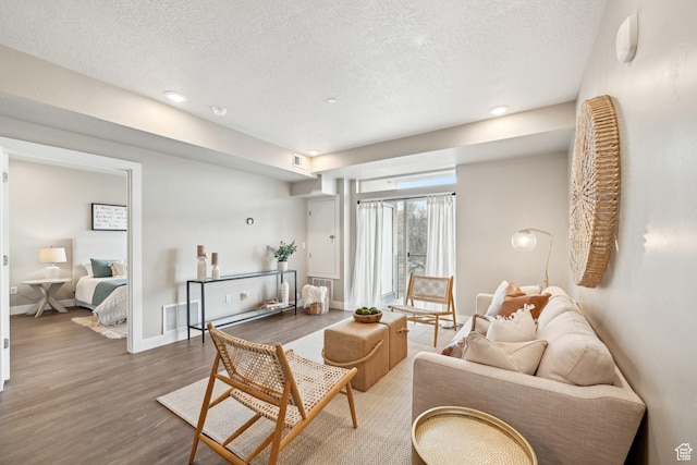 2101 N Main St W Unit 302, Sunset, UT 84015 - living area featuring visible vents, a textured ceiling, baseboards, and wood finished floors