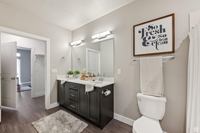 2101 N Main St W Unit 302, Sunset, UT 84015 - bathroom featuring a textured ceiling, toilet, wood finished floors, vanity, and baseboards