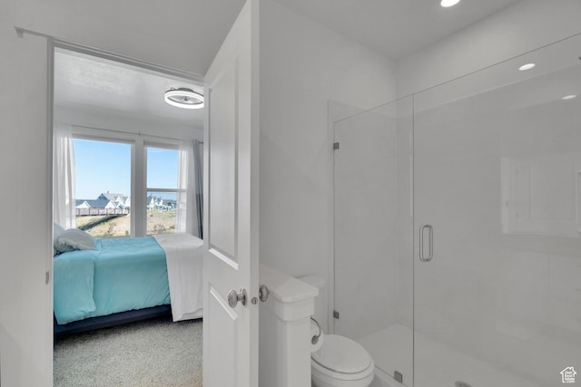 ensuite bathroom featuring a stall shower, ensuite bath, and toilet
