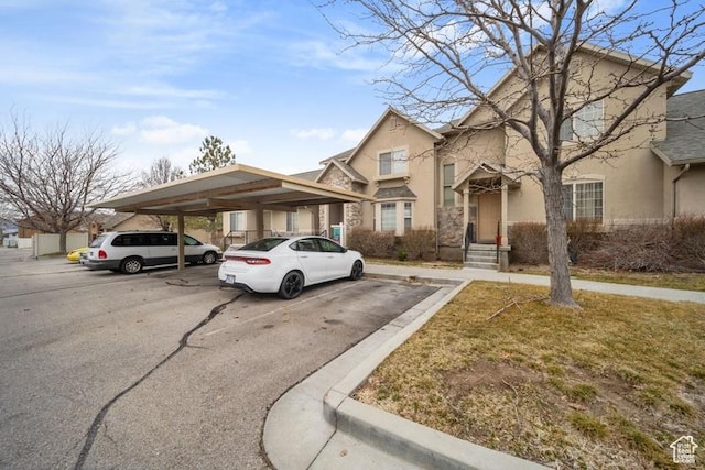 view of front of home with covered and uncovered parking and stucco siding