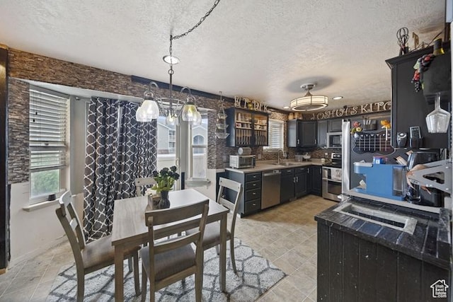 204 W Crescent View Ln N Unit 111, Tooele, UT 84074 - kitchen featuring a textured ceiling, a sink, light countertops, appliances with stainless steel finishes, and pendant lighting