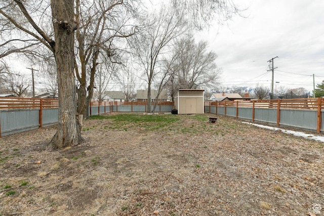 view of yard with a fenced backyard, an outdoor structure, and a shed