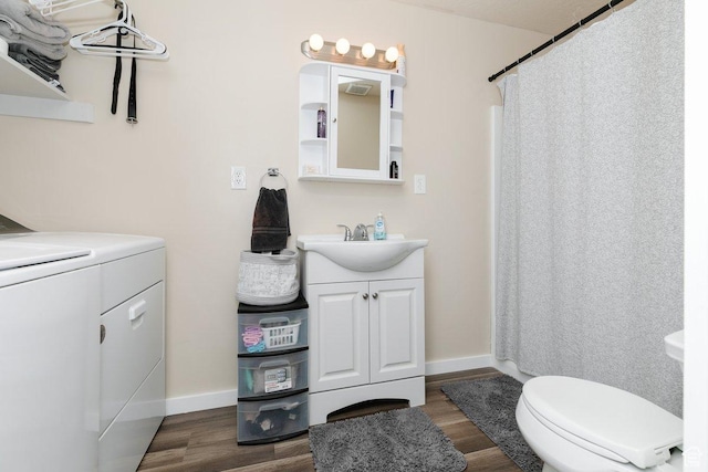 bathroom with washer / clothes dryer, wood finished floors, and vanity