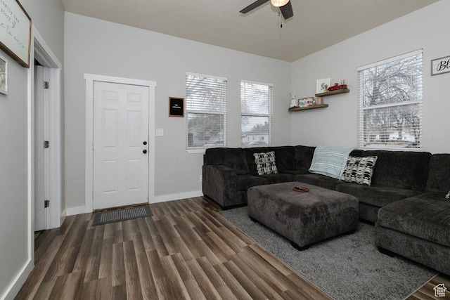 living area featuring a ceiling fan, baseboards, and wood finished floors