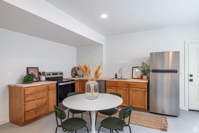 4623 N Festival Way, Eagle Mountain, UT 84005 - kitchen with a sink, recessed lighting, brown cabinetry, light countertops, and appliances with stainless steel finishes