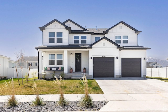 modern inspired farmhouse featuring driveway, board and batten siding, covered porch, fence, and a garage
