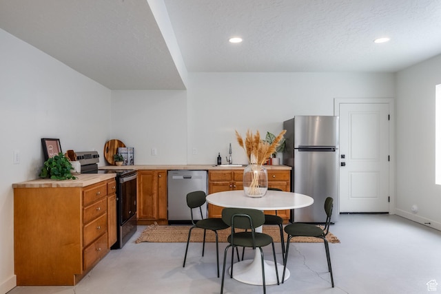 4623 N Festival Way, Eagle Mountain, UT 84005 - kitchen featuring brown cabinetry, appliances with stainless steel finishes, light countertops, and recessed lighting