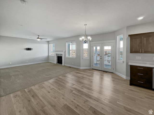 456 E 3675 N, North Ogden, UT 84414 - unfurnished living room featuring light wood finished floors, baseboards, french doors, a fireplace, and ceiling fan with notable chandelier