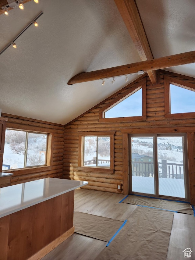 1538 N Mackinaw Way, Garden City, UT 84028 - kitchen with a textured ceiling, light wood-type flooring, beamed ceiling, rustic walls, and track lighting