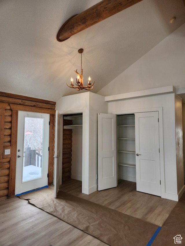 1538 N Mackinaw Way, Garden City, UT 84028 - interior space with access to exterior, vaulted ceiling with beams, multiple closets, wood finished floors, and baseboards