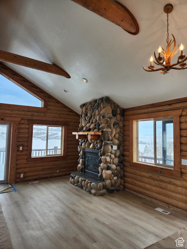 1538 N Mackinaw Way, Garden City, UT 84028 - unfurnished living room featuring lofted ceiling, wood finished floors, a textured ceiling, a stone fireplace, and a notable chandelier
