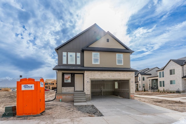 view of front of property featuring driveway, an attached garage, and stone siding